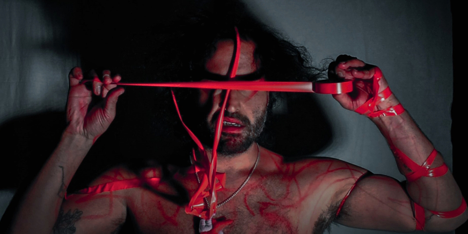 Luis Noguera with red tape and red paint on his body.