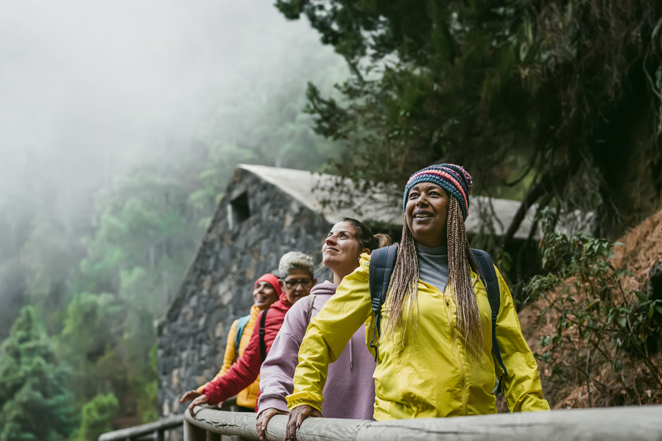 Four women walking in foggy forest.