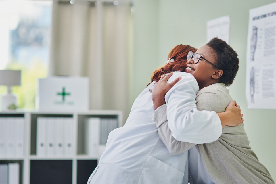 Medical Provider and patient hugging.