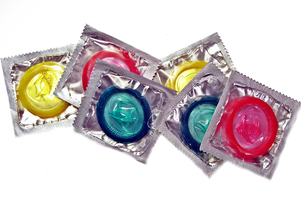 Varios condones de colores visibles a través de envases transparentes.