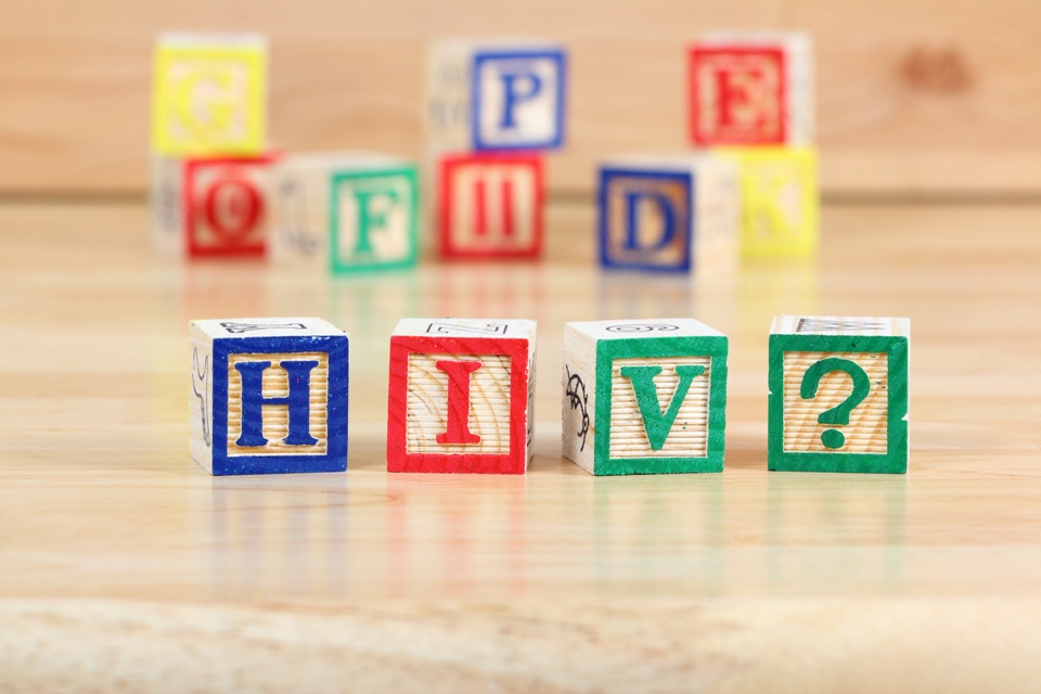 Colorful lettered baby blocks with some spelling out &quot;H I V ?&quot;