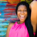 Masonia Traylor, smiling, standing in front of a colorful wall.