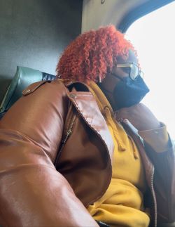 A Girl Like Me blogger Kimberly Canady sitting on a train with a mask on, looking out the window.