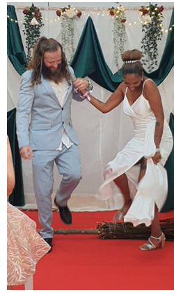 Louise and her partner jumping the broom on their wedding day.