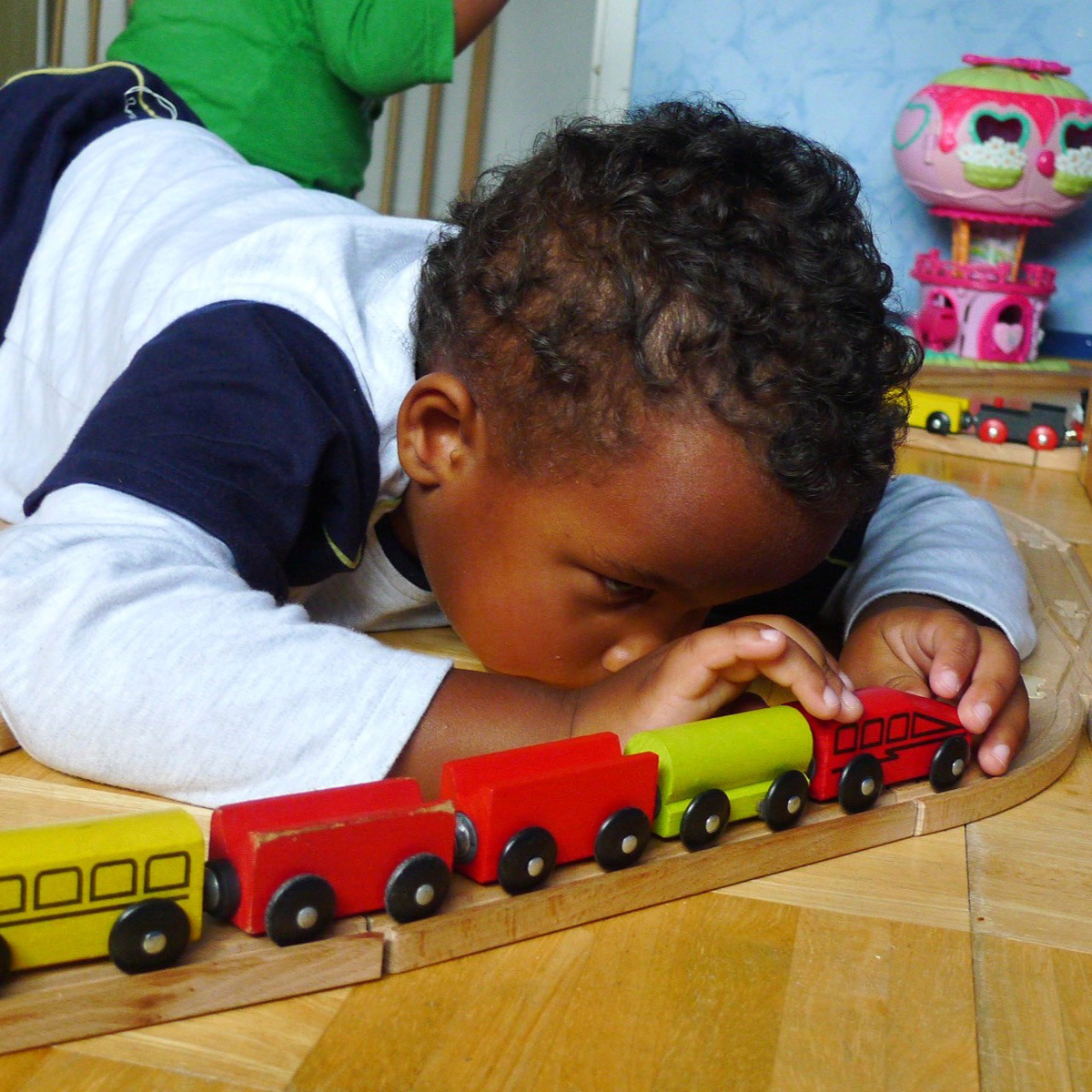 Young boy playing with train.