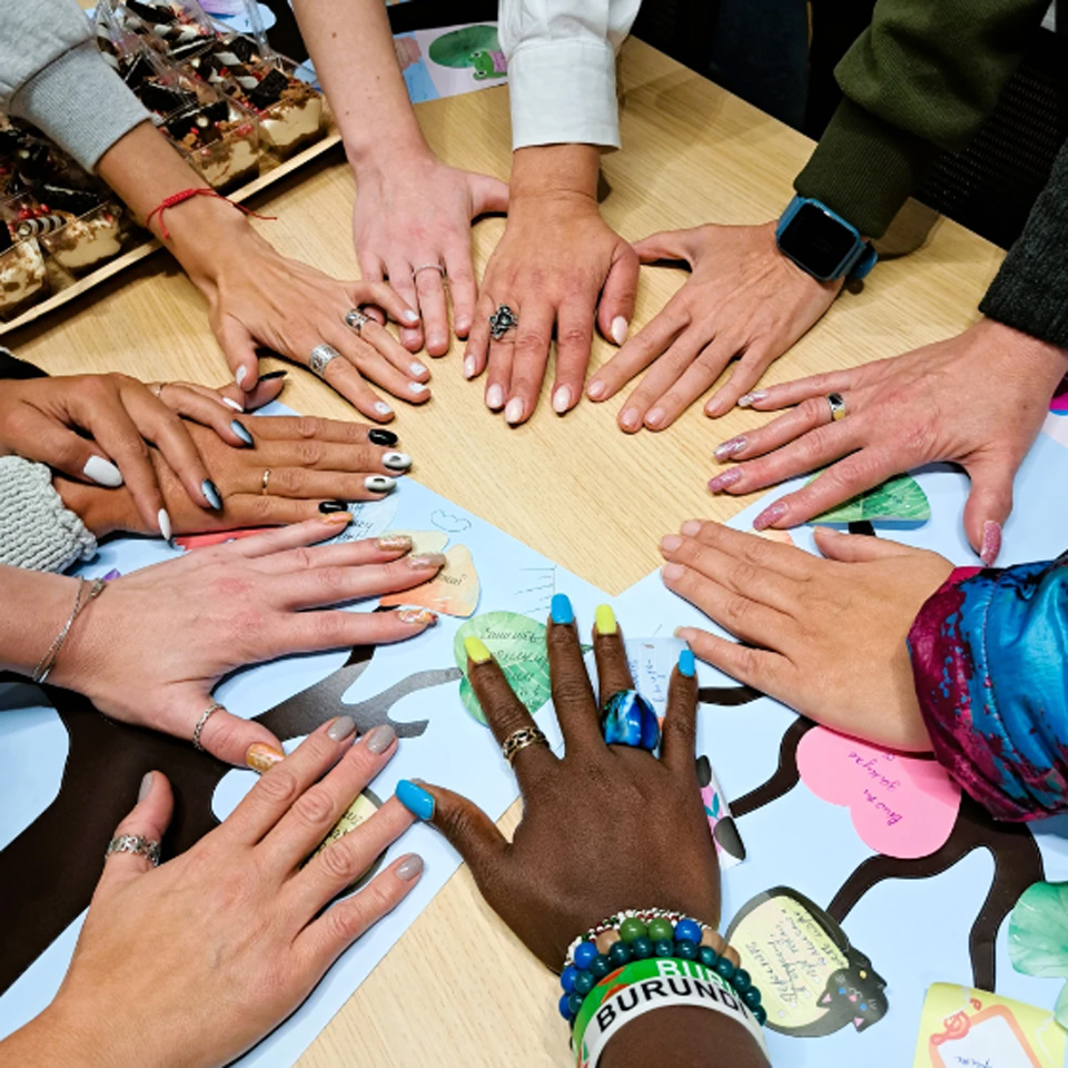 Many hands together in a circle.