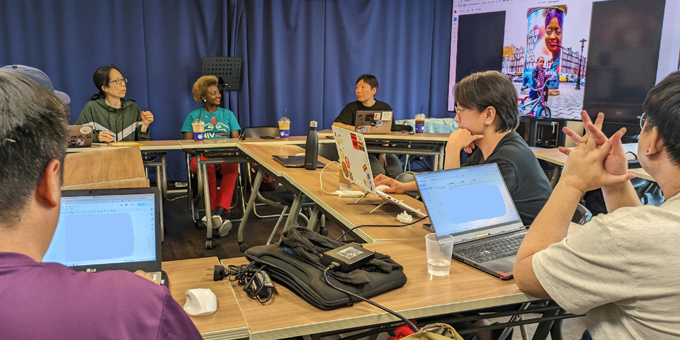 Eliane and others sitting at desks at a meeting about HIV in Korea.