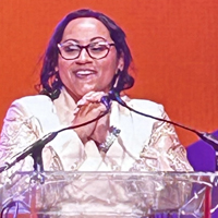 Marissa Gonzalez standing on stage at a podium.