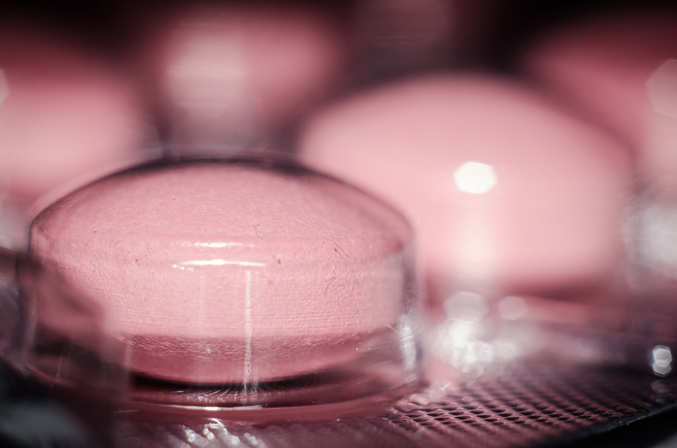 Pink medication tablet in clear inner packaging.