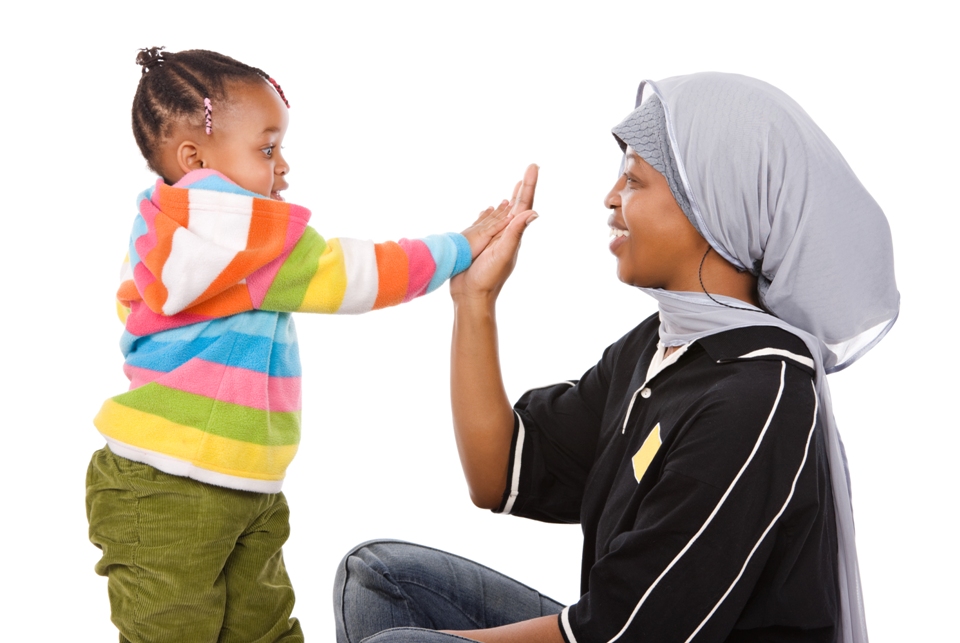 Woman high-fiving a young child.
