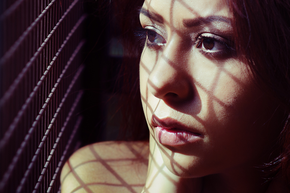 Rostro de mujer con sombras entrecruzadas.