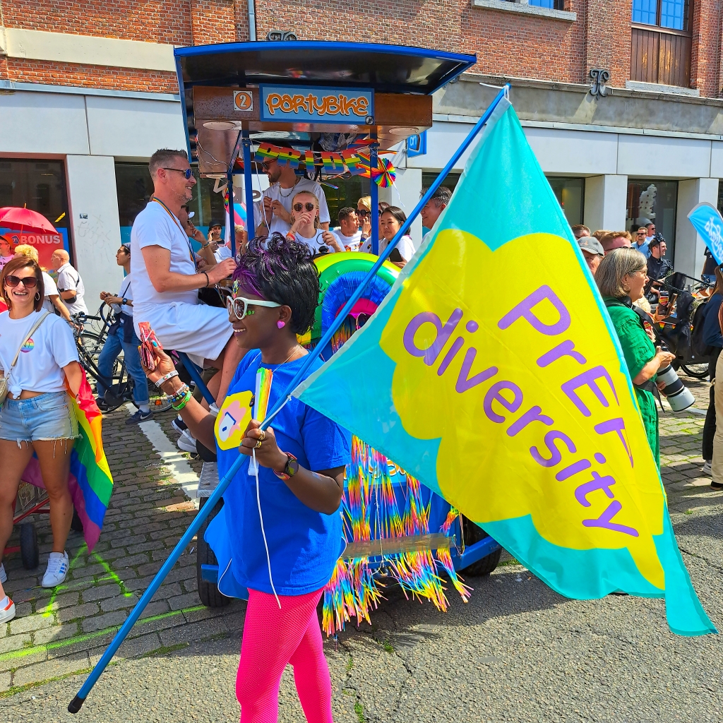 Eliane (HIVstigmafighter) holding a sign that reads &quot;PrEP Diversity&quot; at Antwerp Pride.