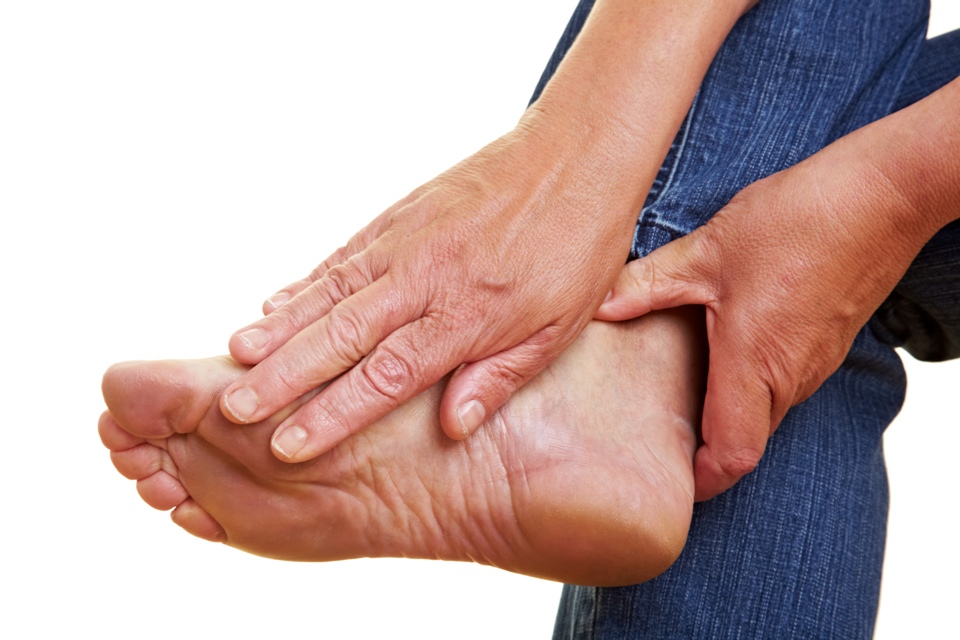 Person's hands holding and rubbing their foot.