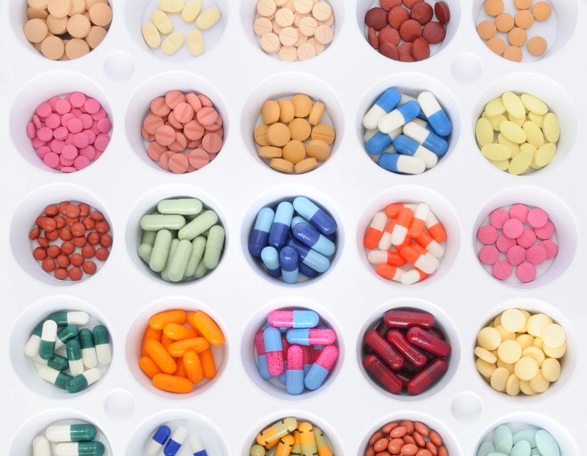Varios tazones de medicamentos de diferentes colores en filas.