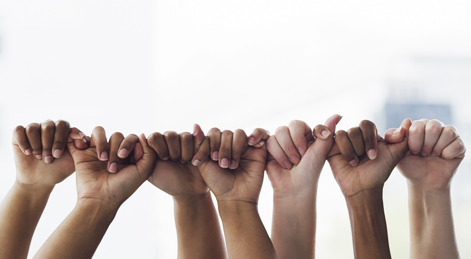 Hands of various skin tones linking pinky to thumb in a row.