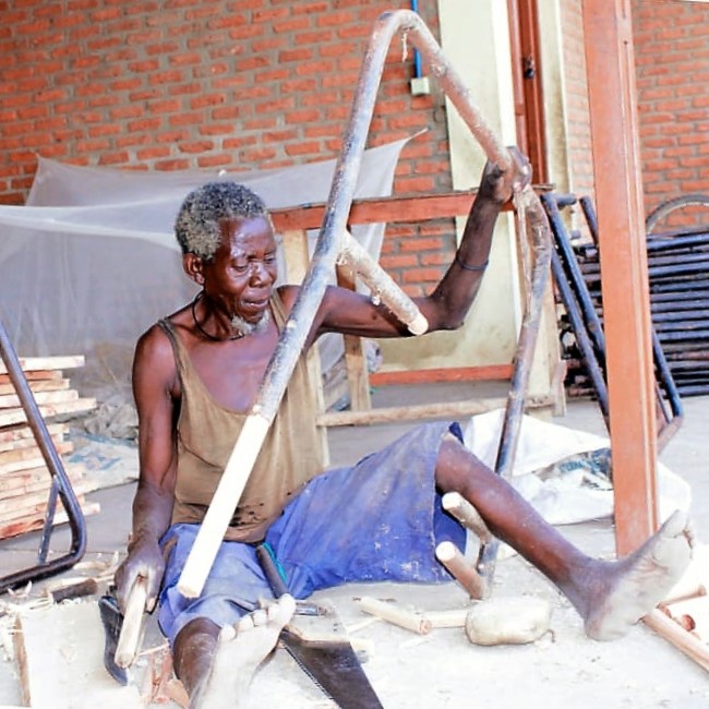 Person sitting on the ground doing construction.