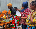 Eliane (HIVstigmafighter) and other women putting food on plates.