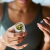 Woman opening a jar of legal marijuana (cannabis/weed).