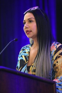 Maria Mejia speaking at a podium.