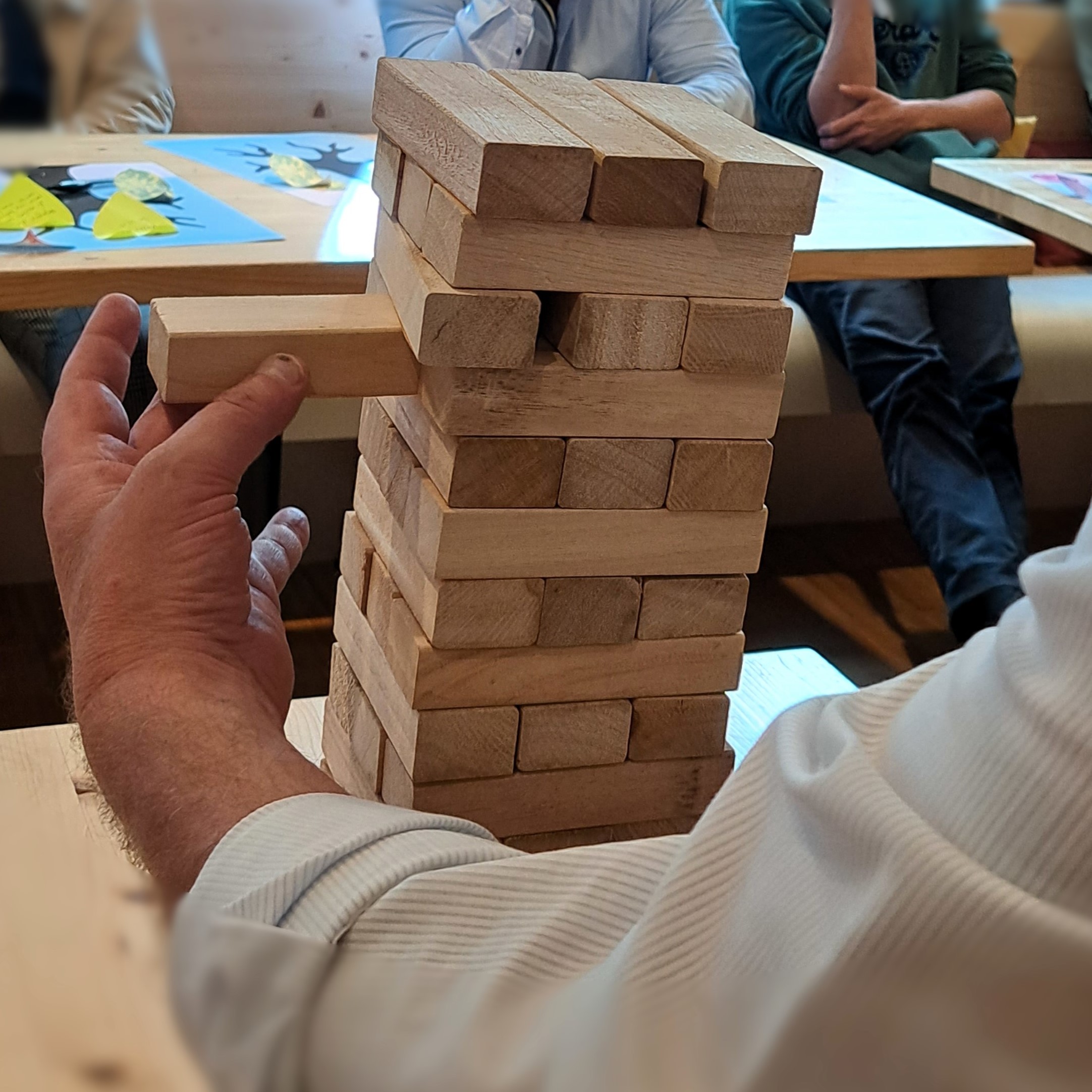 Person playing &quot;Tower of Trust&quot; with Jenga game.
