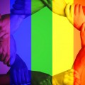 Multiple people's arms linking with a rainbow-colored overlay.