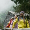 Four women walking in foggy forest.