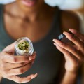 Woman opening a jar of legal marijuana (cannabis/weed).