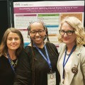 Shannon Weber, MSW; Olivia Ford; and Krista Martel stand in front of poster at conference.