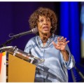 Maxine Waters speaking at a podium.