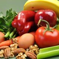 Frutas, verduras, nueces y huevos sobre una mesa.