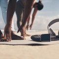 Two women stretching at the beach.