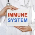 Person dressed in medical garb holding sign that reads "Immune System".