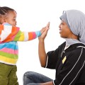 Woman high-fiving a young child.