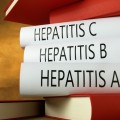 Stack of six books, three of which are labeled "Hepatitis A", "Hepatitis B", and "Hepatitis C". 