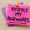 Bright post-it notes thumbtacked to fabric, one with the words "Respect My Hormones".