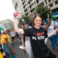 Mujer sonriendo, vistiendo una camiseta que dice "HIV Positive", en una marcha.