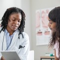 Mujer sentada hablando con su proveedor de atención médica.