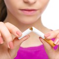 Closeup of woman breaking a cigarette in half.