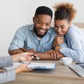 A smiling couple sitting with a healthcare provider.