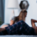 Blurry photo of two people lying on bed talking.