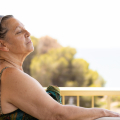Woman with her eyes closed, and face to the sun.