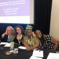 Krista Martel; Marielle Gross, MD; Claire Gasamagera; & Ciarra Covin seated at table at conference.