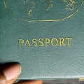 Fingers holding a passport.