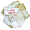 Pile of unopened mail with "past due" and "final notice" stamped on some of the envelopes.
