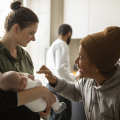 Tres personas en una cocina, una de ellas sosteniendo a un bebé.