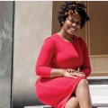 Masonia Traylor, smiling, seated outside near a wall that reads "Nelson Mandela".