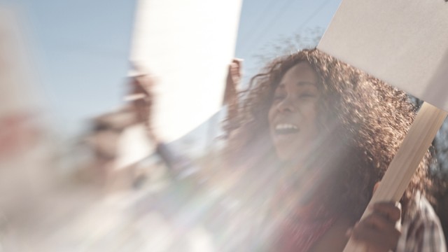 A woman in a group of protesters at a rally.