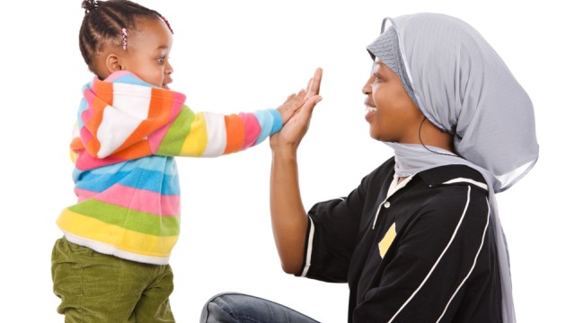 Woman high-fiving a young child.