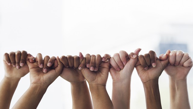 Hands of various skin tones linking pinky to thumb in a row.