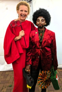Eliane as Eric the Dragking standing next to a woman in red.